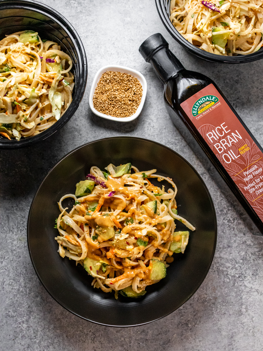 Nutty peanut noodles in a bowl with rice bran oil bottle
