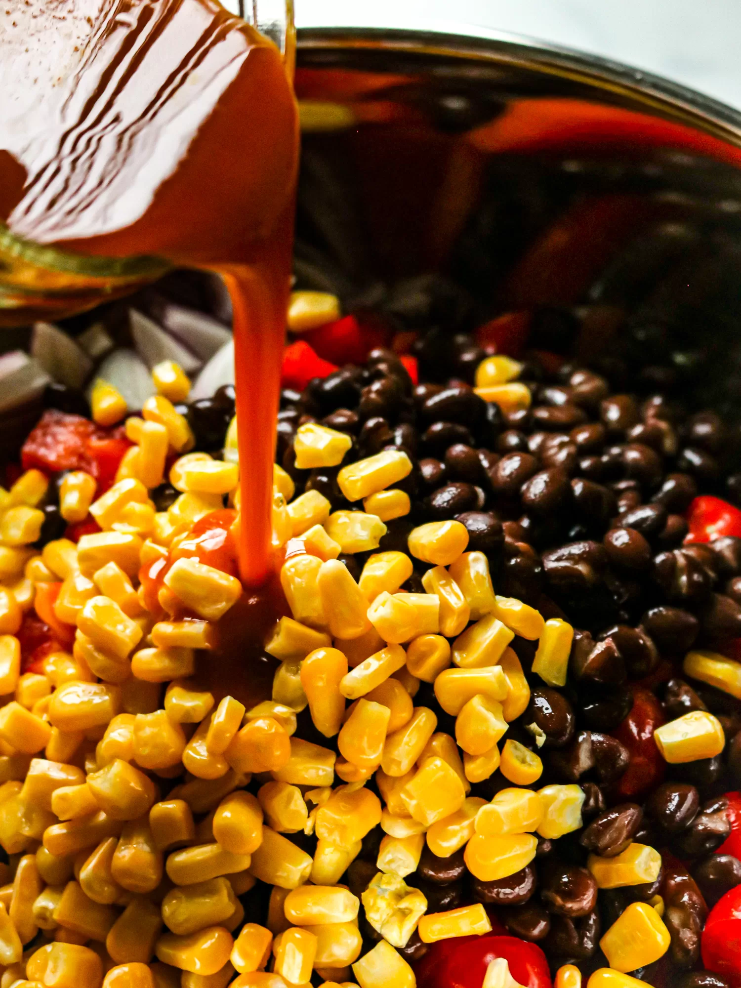 Southwestern pasta salad with dressing poured over ingredients